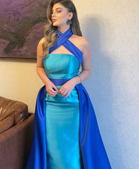 Indoor full-length view of a blue and turquoise satin halter gown with a sleek mermaid fit and dramatic contrast drape.