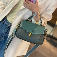 Shell-shaped leather shoulder bag with smooth finish and polished hardware