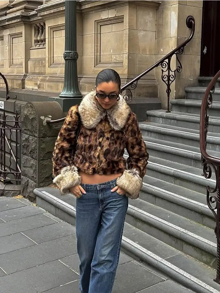 Person wearing a leopard print coat with fur trim on a city street.
