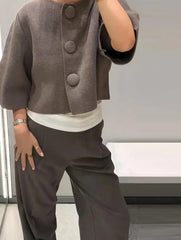 Cropped gray cardigan styled buttoned up, showing the boxy drape through the body and the short, wide sleeves.