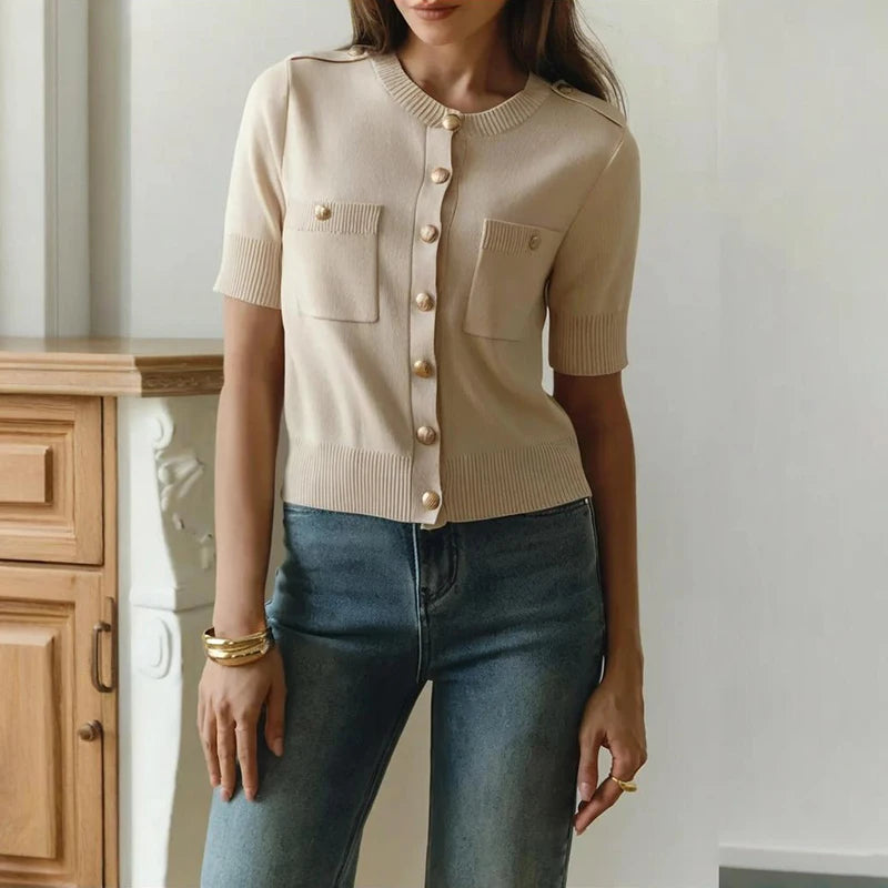 Person wearing a cross-view of slim-fit beige cardigan top for summer and blue jeans indoors.