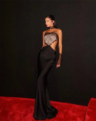 Side profile highlighting the dramatic cut-out detailing and flowing sheath silhouette for a refined evening look.