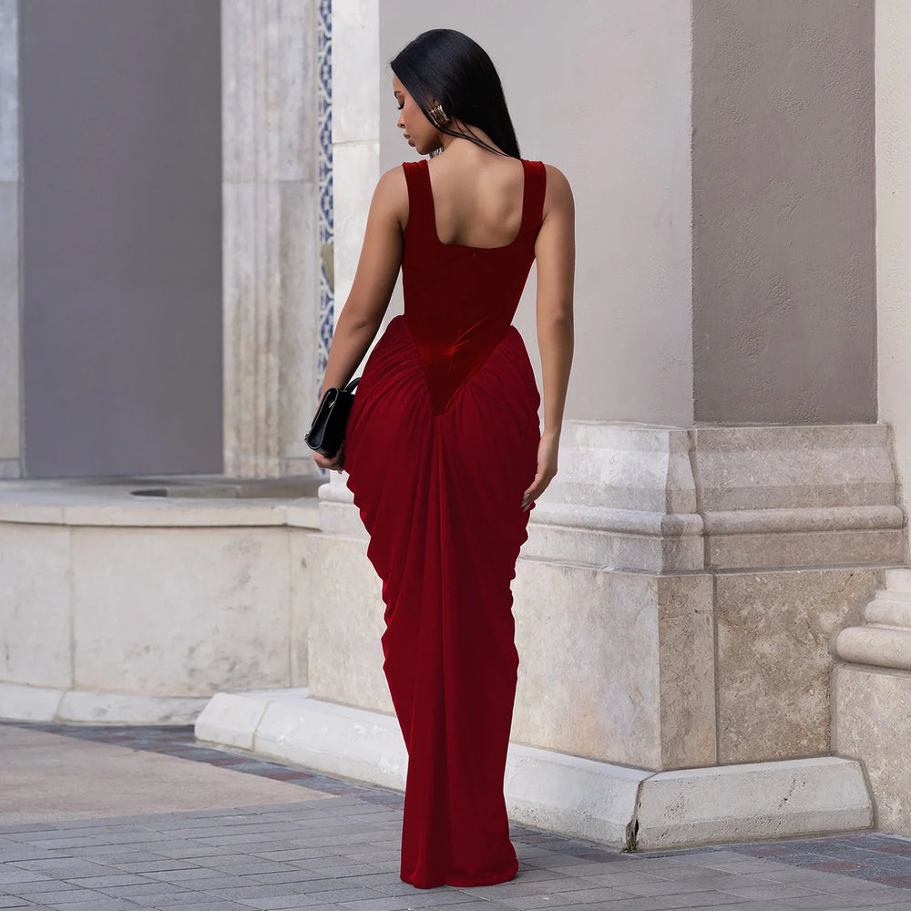 Back view showing stacked ruching down the skirt on a deep red sleeveless velvet dress styled for an evening setting.