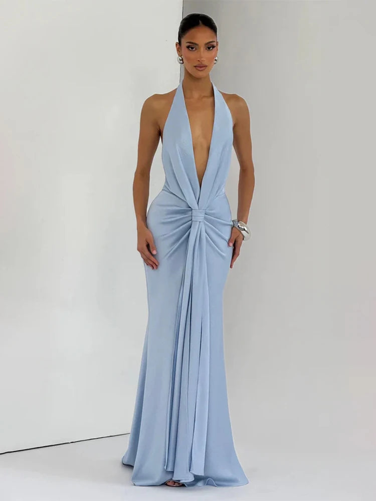 Backless satin evening dress shown in a soft summer-light backdrop.