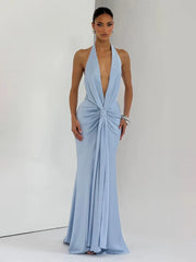 Backless satin evening dress shown in a soft summer-light backdrop.