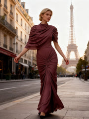 Lifestyle image of a ruched shoulder evening dress captured mid-step, highlighting the soft folds and elongated column silhouette.