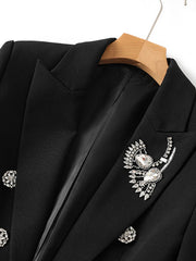 Detail view of the black blazer lapel and collar, showing smooth fabric texture and precise tailoring.