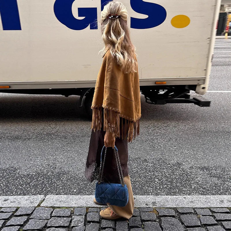 Full outfit view showing the wide, relaxed cape silhouette and fringe hem movement, designed for spring and autumn layering.