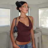 Woman wearing a wine red halter tank styled for Pinterest-inspired streetwear and denim shorts in a modern indoor setting