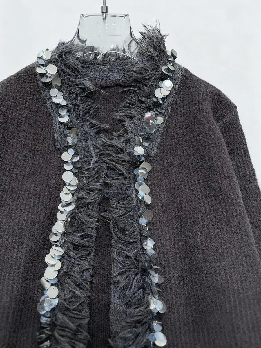 A relaxed knit jacket styled with trousers for transitional weather and premium casual mood.