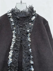 A relaxed knit jacket styled with trousers for transitional weather and premium casual mood.