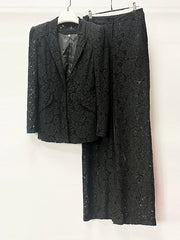 Black textured suit jacket and pants on a white background