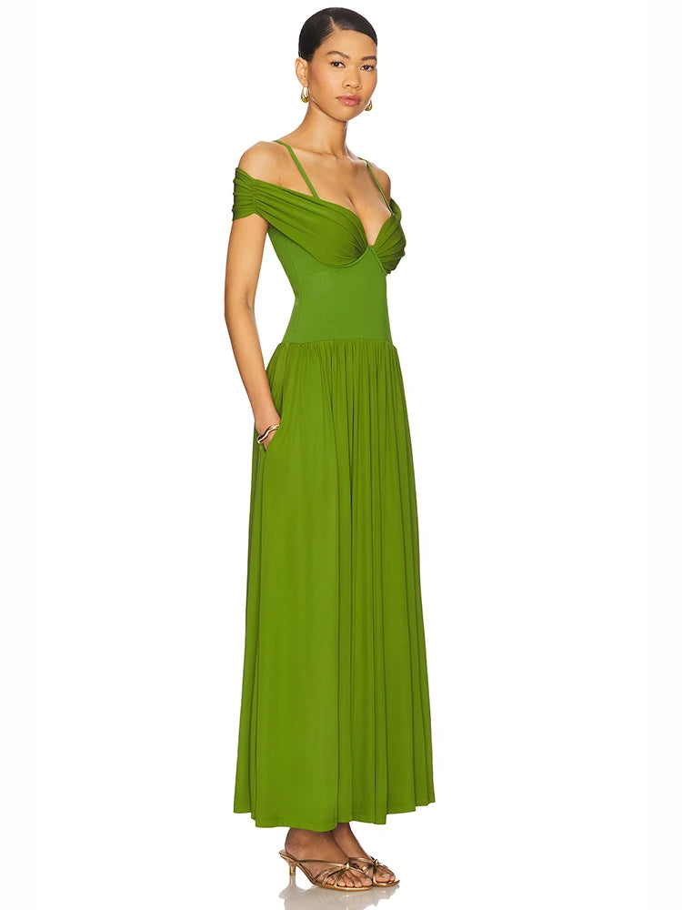 Woman wearing a elegant green dress with pleated A-line skirt and slim fit bodice on a white background