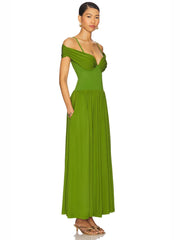 Woman wearing a elegant green dress with pleated A-line skirt and slim fit bodice on a white background
