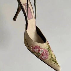 High-heeled shoe with floral embroidery on a light gray background