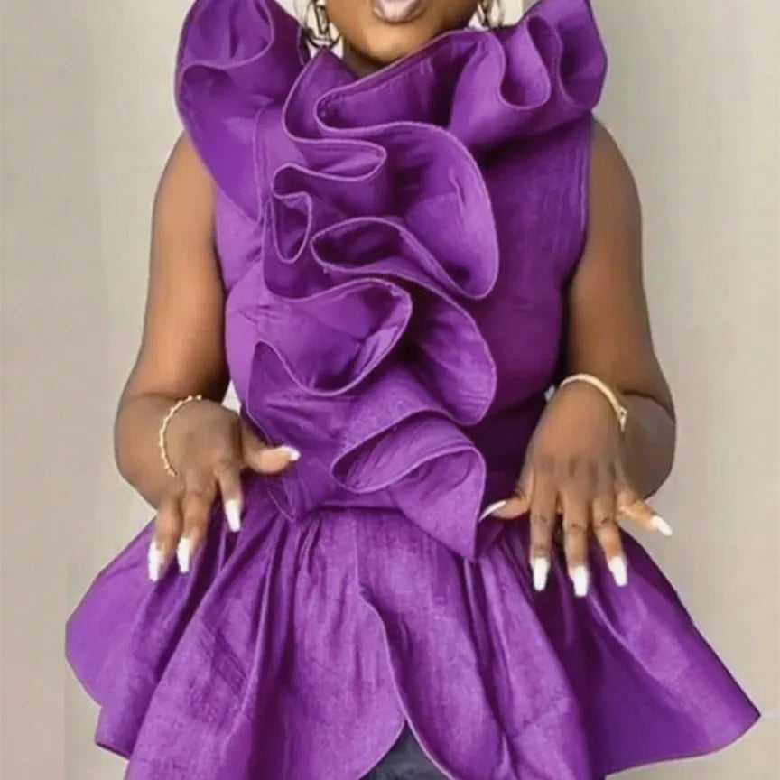 Woman wearing a vibrant purple dress with ruffled details against a neutral background