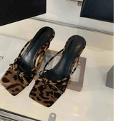 Close-up of leopard wedge heel party slides on neutral floor