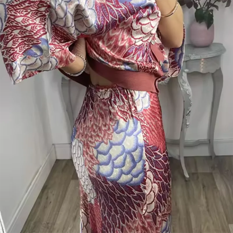 Side view of a person wearing a colourful floral dress in a room with a white wall and wooden floor.