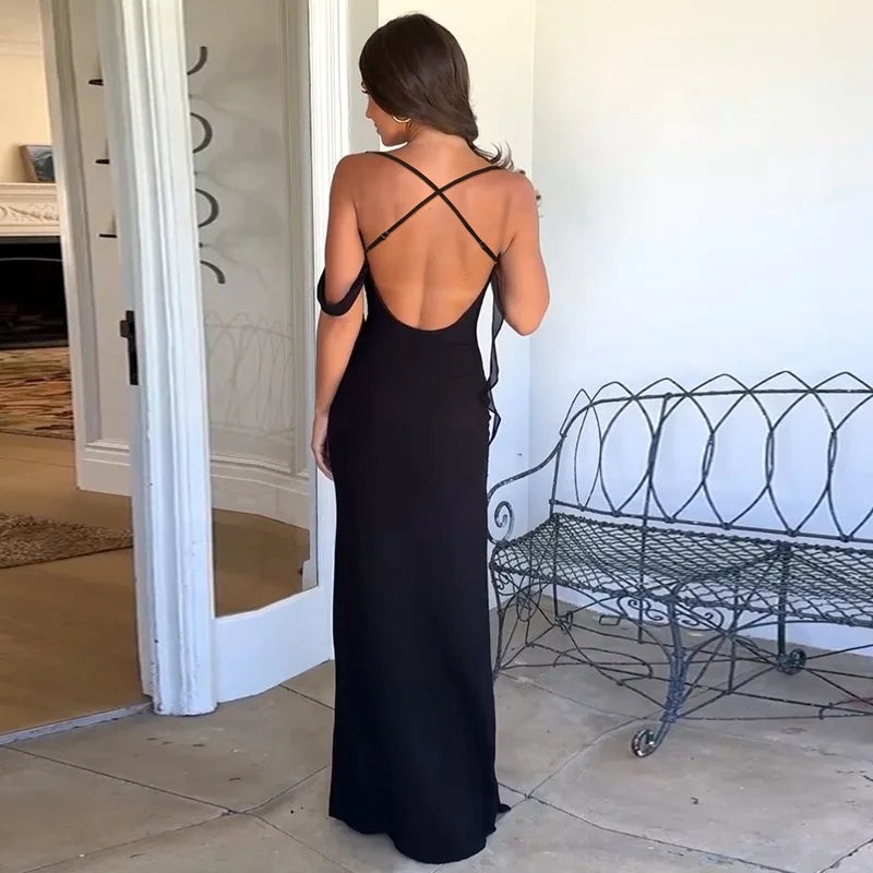 Woman wearing a elegant black dress with backless design and soft drape in a room with a wire bench.