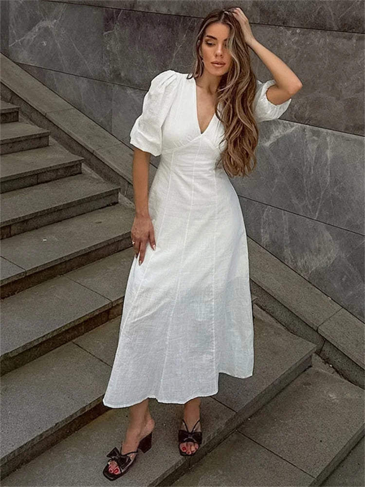 Elegant white midi dress styled on stone steps outdoors