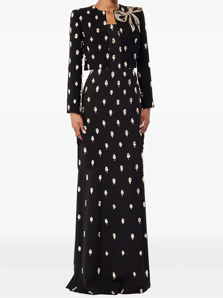 Model wearing a maxi dress with an all-over embellished motif and a cropped blazer, styled as a coordinated formal set on a studio background.