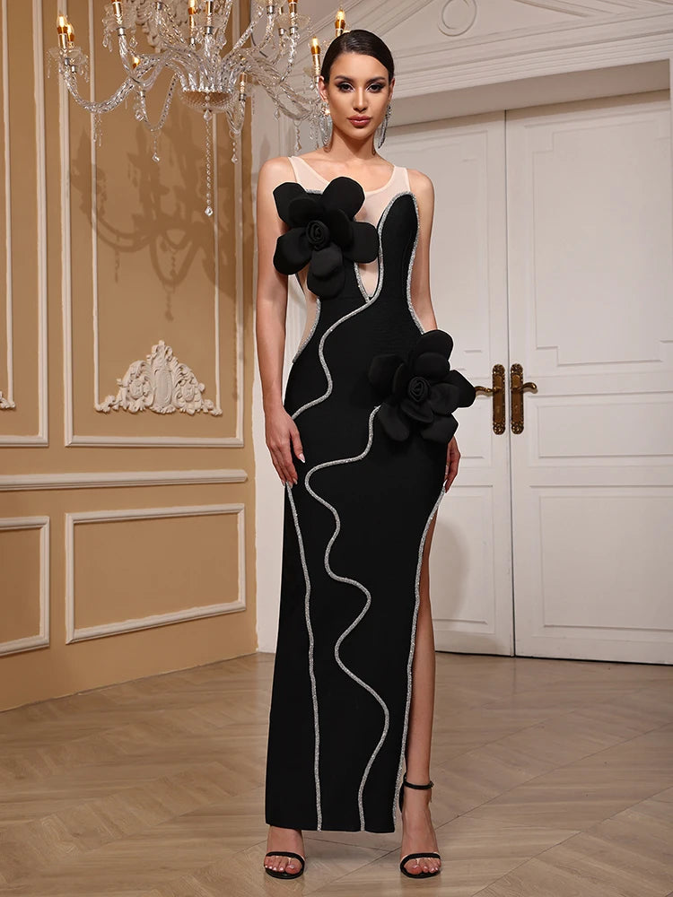 Woman wearing a black and white evening gown with floral details in an elegant room.