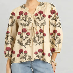 Close-up of the blouse neckline showing floral embroidery and soft tie detail.