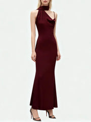 Close-up of neckline showing architectural asymmetry and slim wrapped bodice with a smooth sheath silhouette.