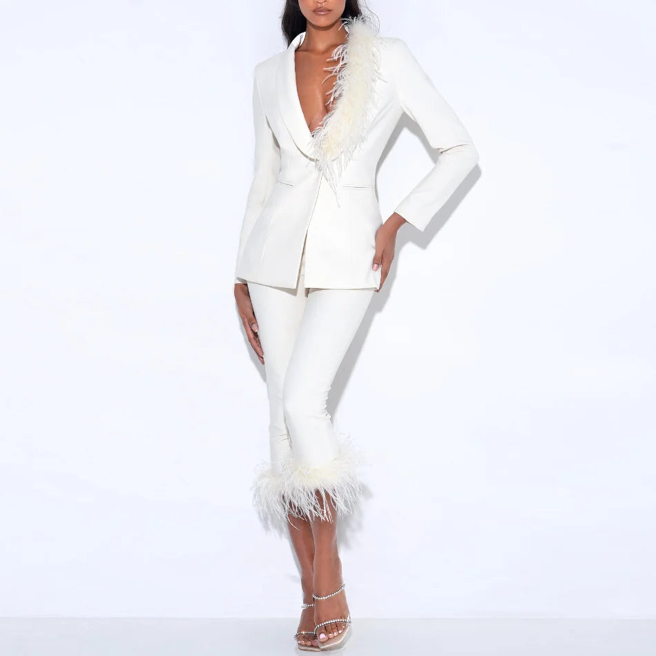 Model wearing a tailored blazer and capri pants set with feather trim, posed confidently against a clean studio backdrop