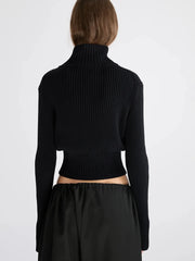 Black zip-up ribbed knit cardigan styled with relaxed trousers.
