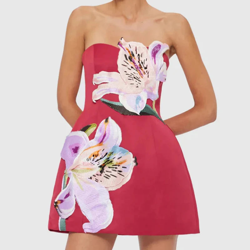 Red strapless mini dress with bold floral artwork shown from the  front  on a white background.