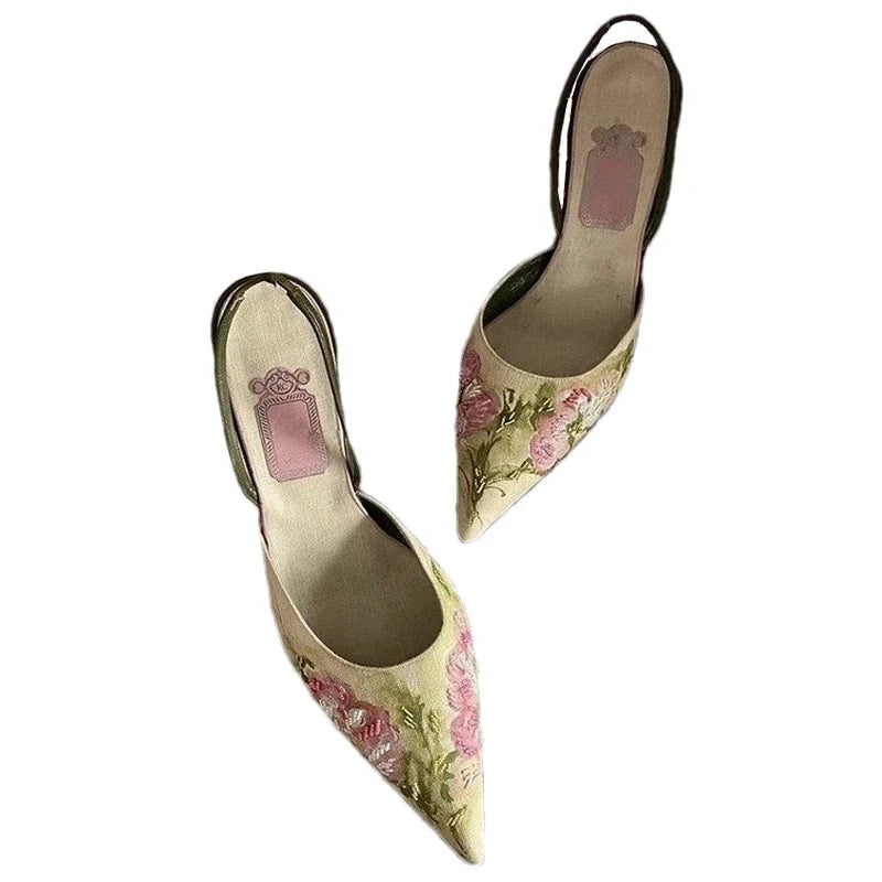 Pair of floral high-heeled shoes on a white background