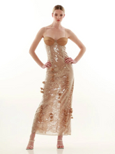 A woman modeling a floral lace maxi dress with sequin appliques.