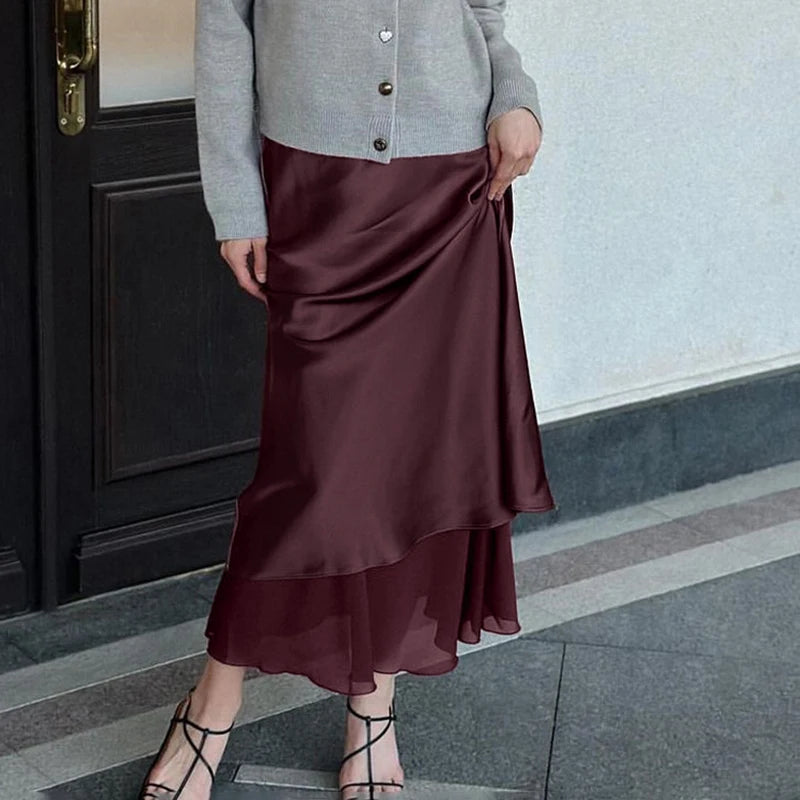 Person wearing a flowy midi skirt, perfect for spring and summer outfits, standing on a sidewalk.