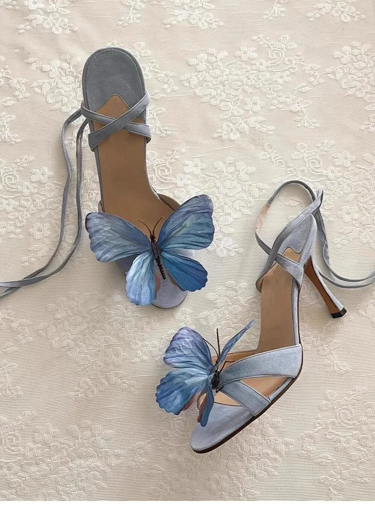 High-heeled shoes with blue butterfly decorations on a textured surface