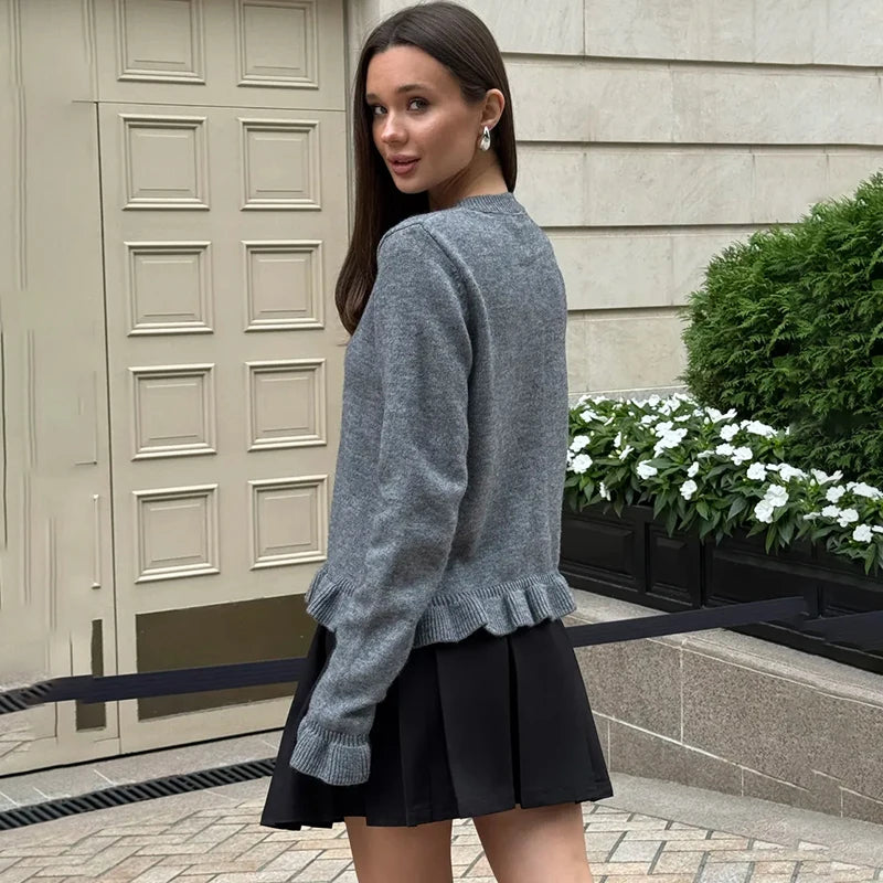 Knit cardigan styled with minimal accessories and feminine skirt for autumn layering
