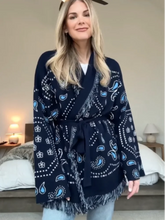 Woman wearing a navy blue patterned scarf in a bedroom setting