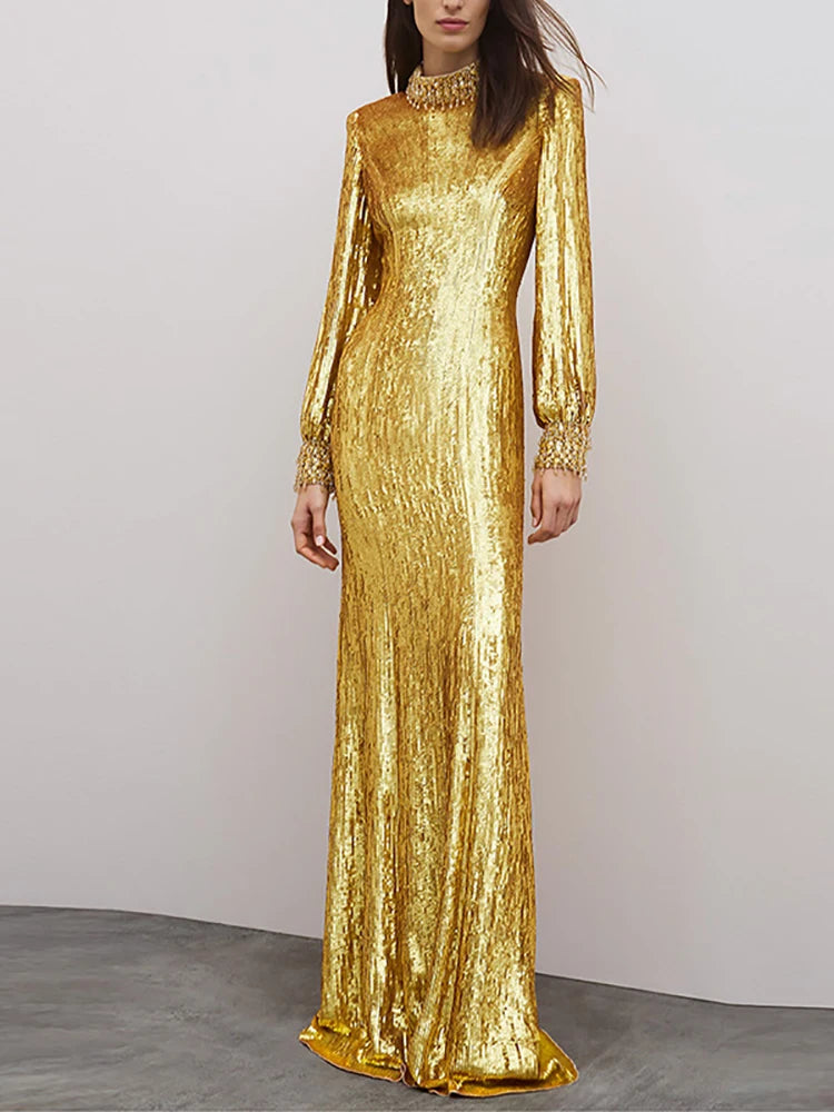 Gold sequined long sleeve maxi dress styled on a model against a soft neutral backdrop.