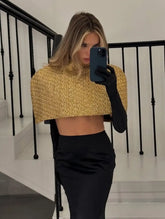 Front view highlighting the structured cape overlay and high neckline on a gold shimmer top with a clean, polished silhouette.