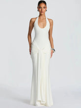 Model wearing an ivory halter backless ruched maxi gown, front view