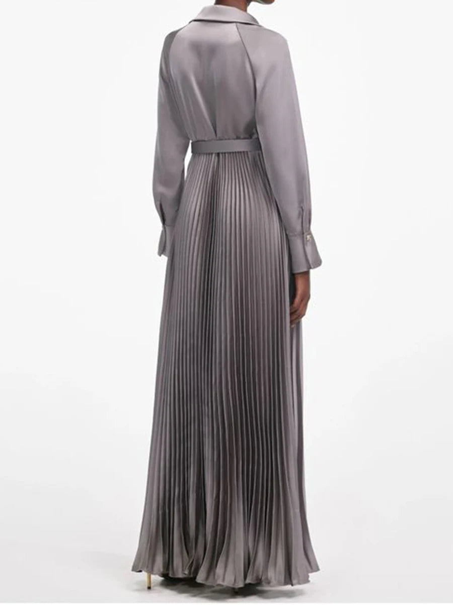 Pleated maxi dress featuring a defined waist and clean tailored finish