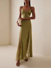 Woman in green maxi dress with lace panels and high slit