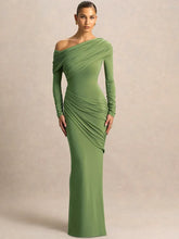 Woman wearing a green one-shoulder ruched maxi dress against beige background