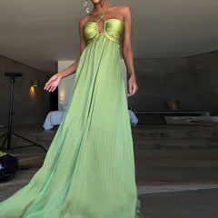Green pleated satin maxi dress styled for elegant vacation evenings