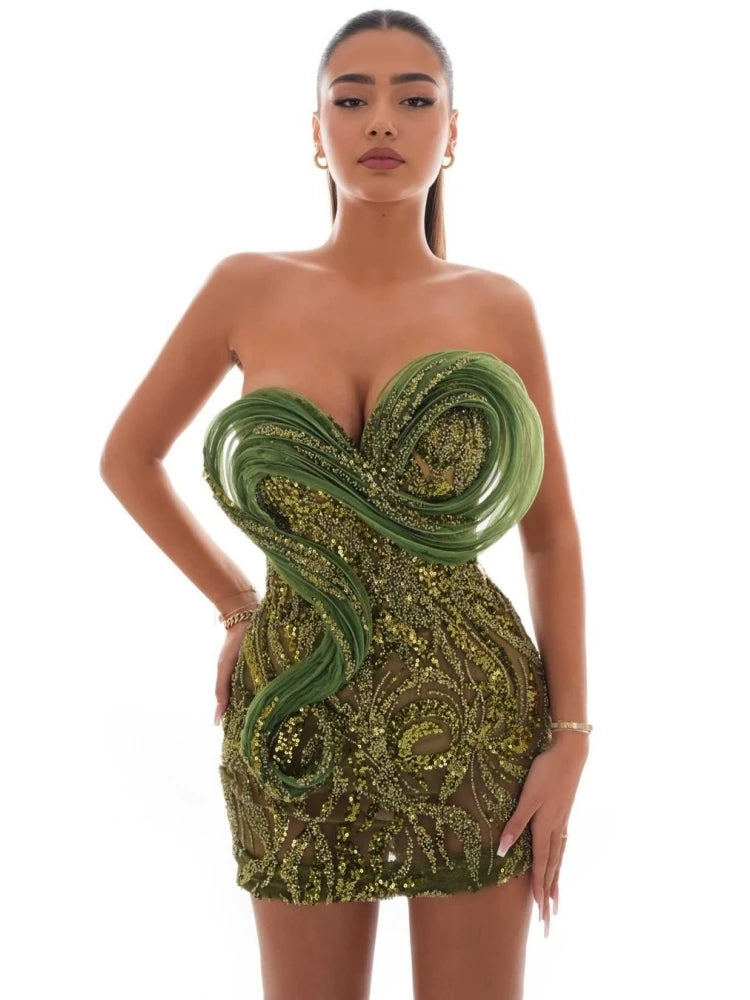 Green strapless sequin mesh mini dress styled for evening cocktails.Woman wearing a green and gold dress with an intricate design on a white background