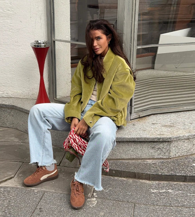Green zipper jacket styled for casual autumn layering on city steps