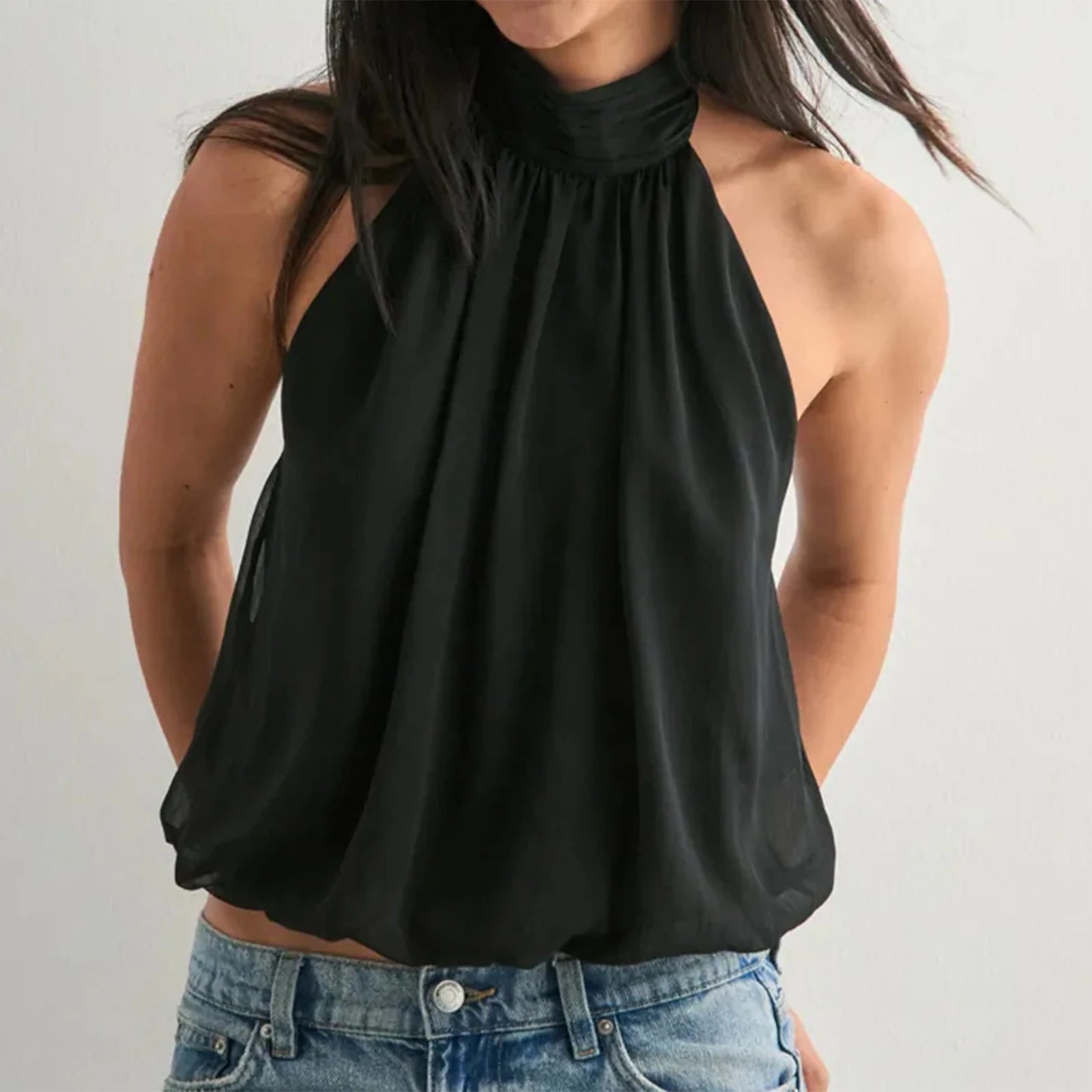 A woman modeling a halter backless loose-fit tank top.