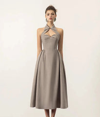 A woman wearing a halter neck backless dress in a chic, modern style.