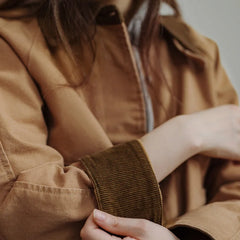 Person wearing a brown jacket with a blurred background