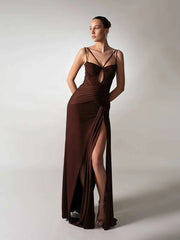 A woman modeling a hollow-out spaghetti strap maxi dress with a high slit.